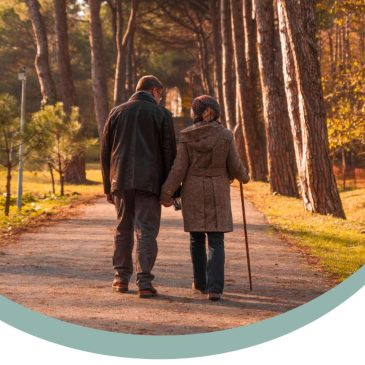 old couple walking through a leafy park